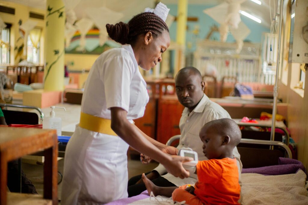 Nurse attending to child in the presence of the father
